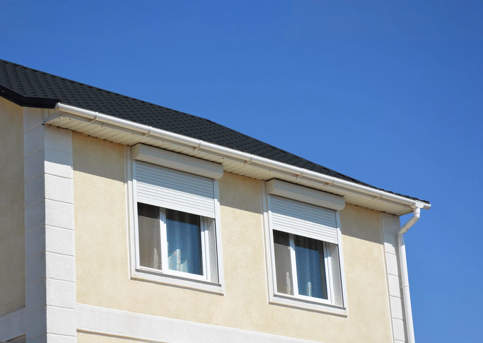 Voorzetrolluiken achteraf geplaatst boven de ramen van een gerenoveerde woning